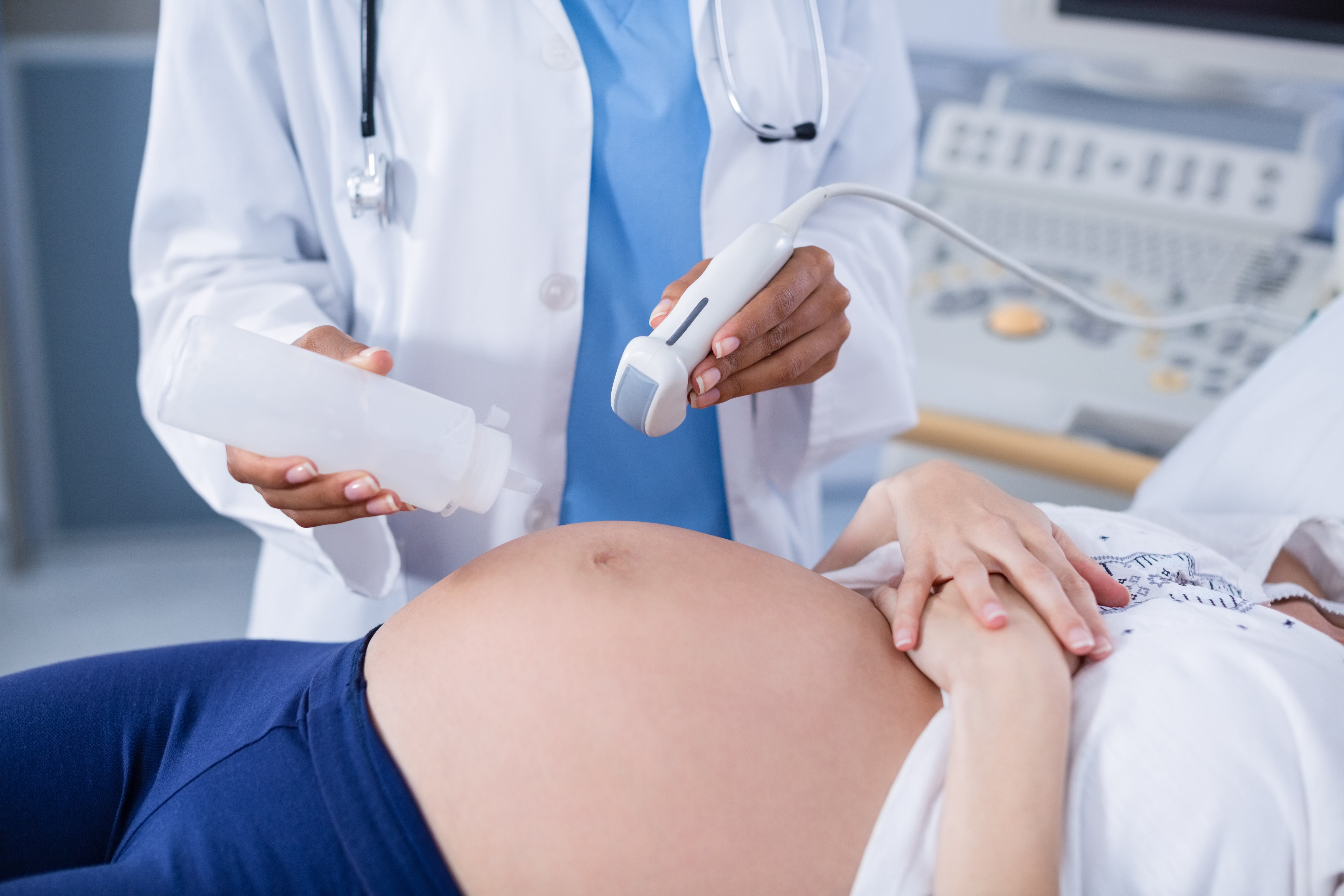 Pregnant woman receiving a ultrasound scan on the stomach in hospital